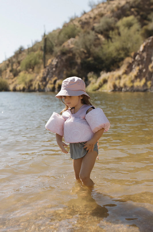 Girl in the water wearing "Sea" You on Top Floaties - Line Rose