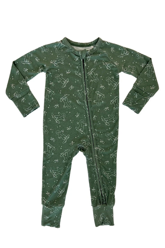 A baby's long-sleeve footless one-piece pajama in dark green with a light gingerbread man skating pattern, featuring a front zipper closure, laid flat on a white background.