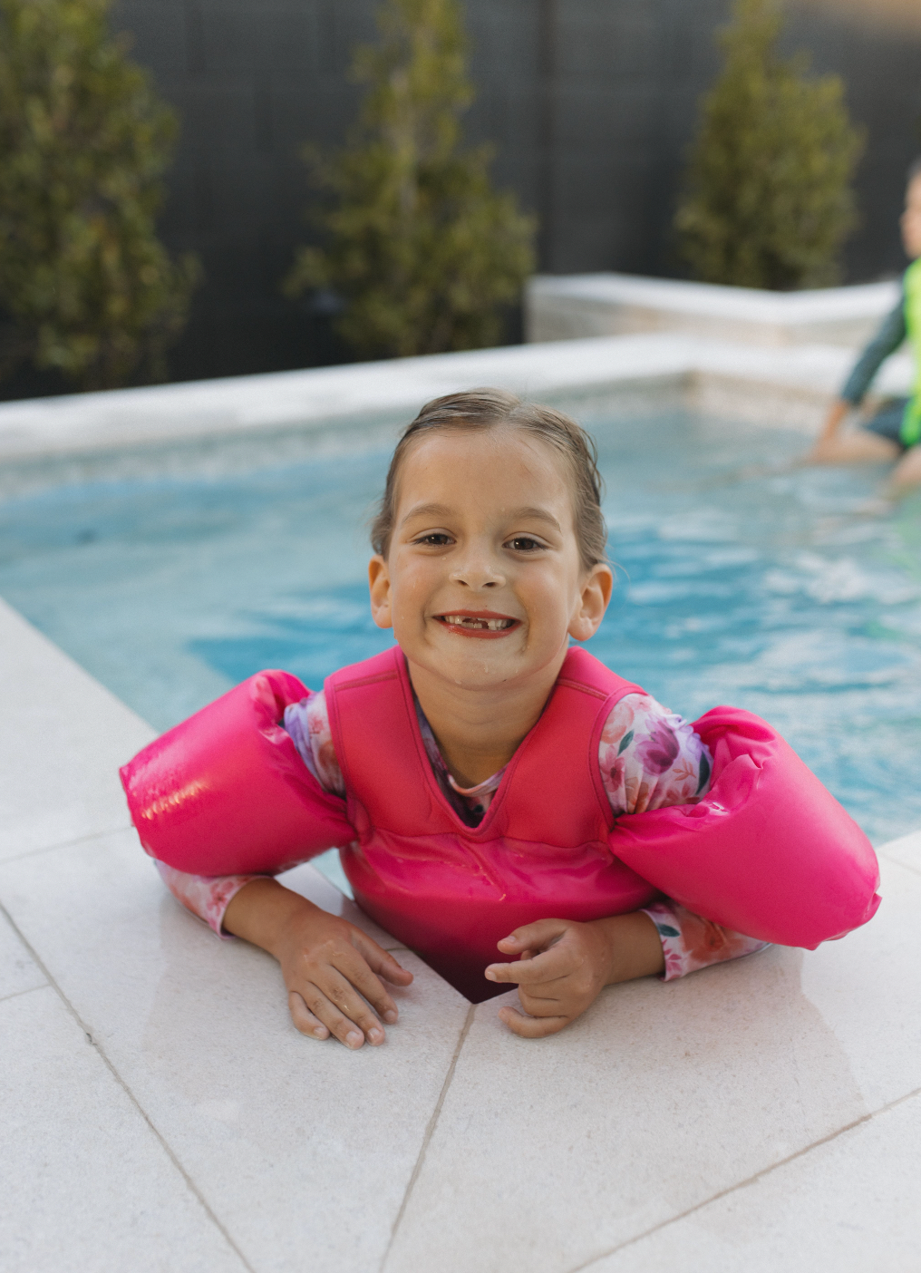 Girl in a pool wearing The "Brights", Hot Pink High Visibility Neon Swim Floaties