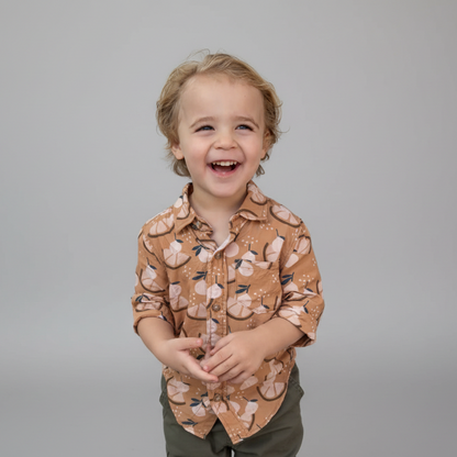 Child wearing a orange slice patterned shirt against a plain background