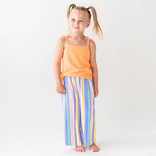 Girl standing wearing Rainbow Lane Stripe Terry Knit Wide Leg Pants and Melon Terry Knit Tie Tank. 